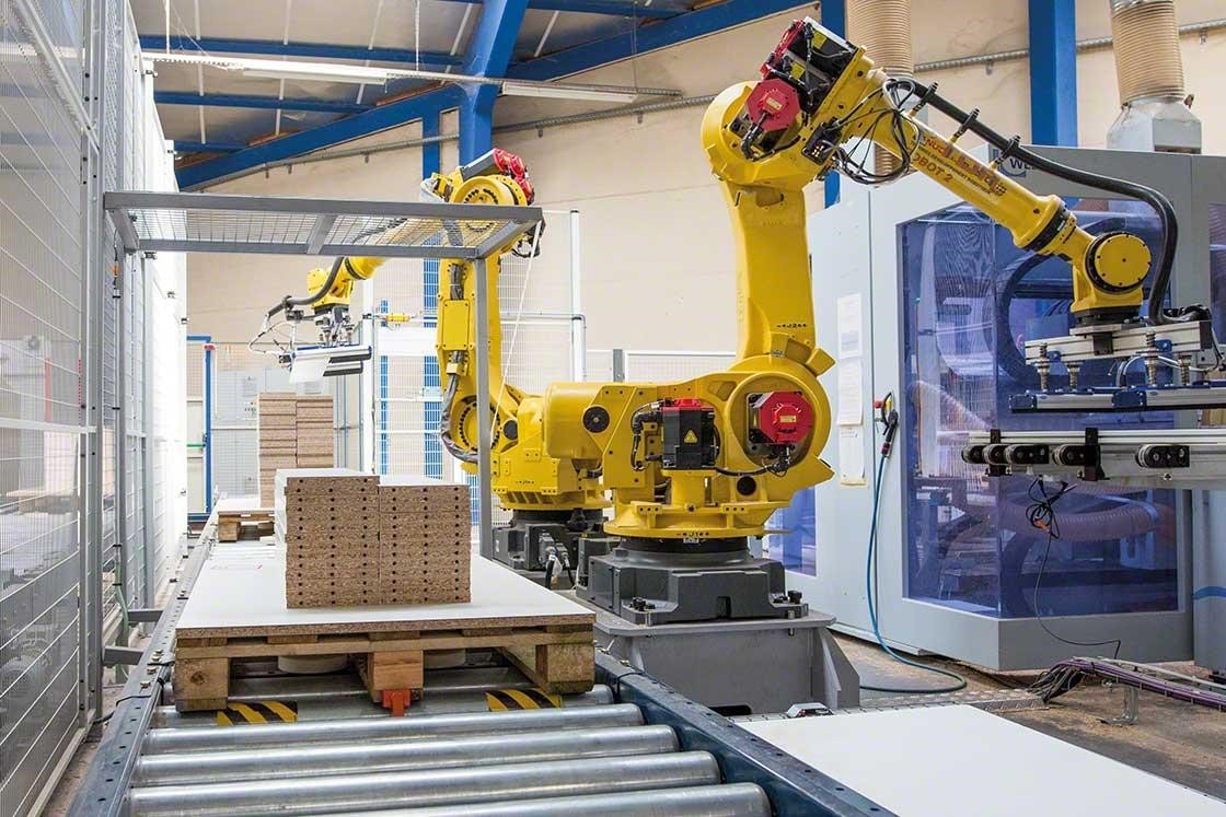 Des bras mécanisés qui réalisent la palettisation des marchandises dans un entrepôt robotisé. Des bras mécanisés qui réalisent la palettisation des marchandises dans un entrepôt robotisé.