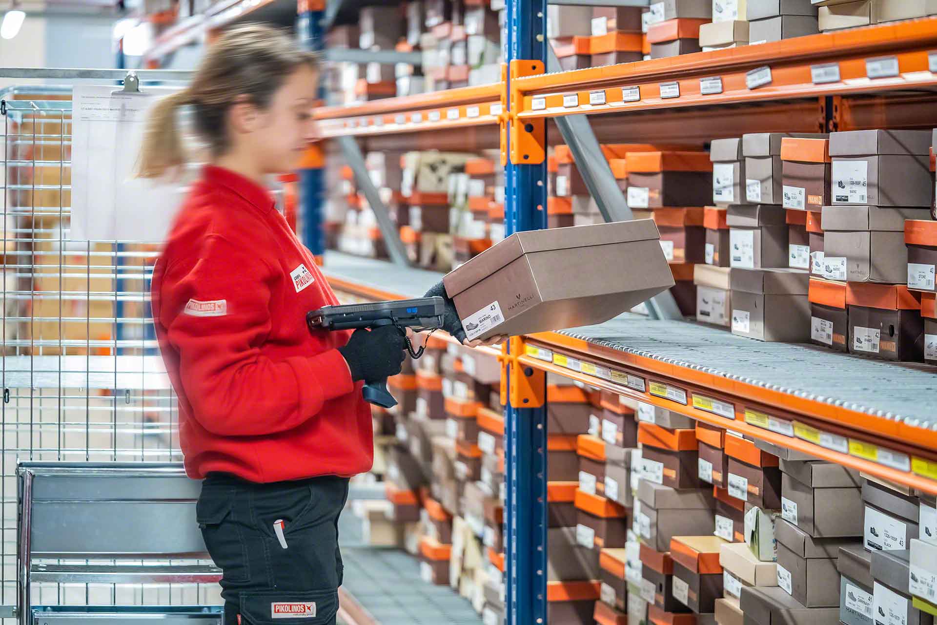 Une employée réalise la préparation de commandes selon la méthode du pick-to-cart Une employée réalise la préparation de commandes selon la méthode du pick-to-cart