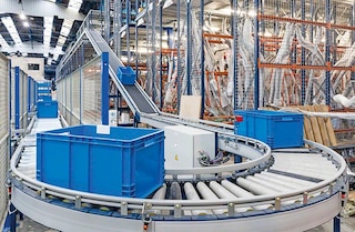 Les convoyeurs de cartons et bacs relient des points éloignés dans l’entrepôt Les convoyeurs de cartons et bacs relient des points éloignés dans l’entrepôt