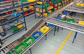 Un circuit de convoyeurs pour bacs relie les rayonnages aux stations de picking