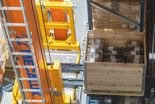 Le système d’extraction récupère la palette et la place sur la nacelle de levage Le système d’extraction récupère la palette et la place sur la nacelle de levage